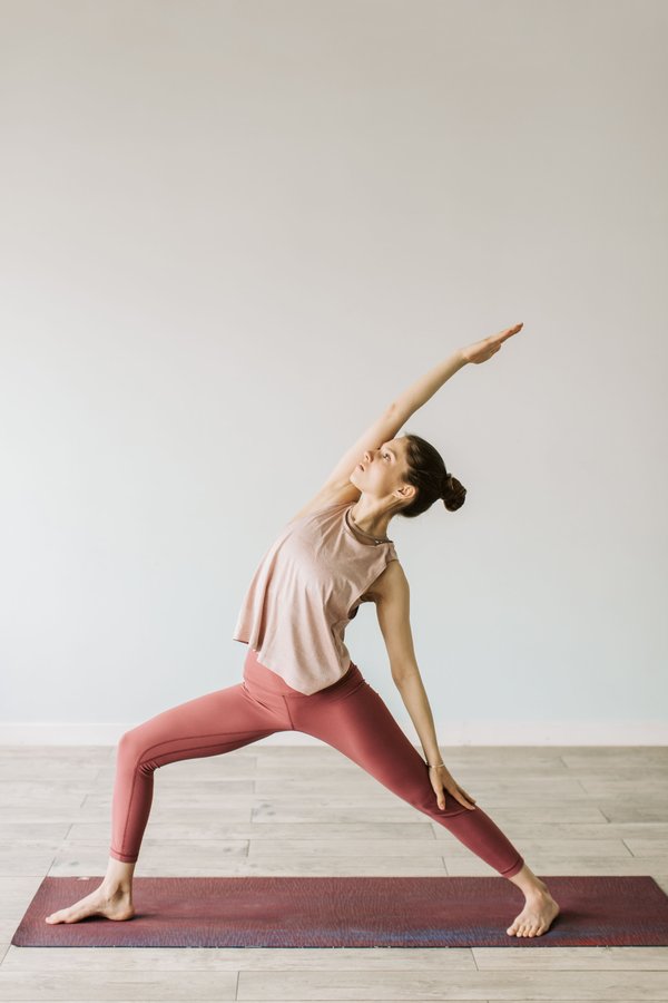 Someone holding a yoga pose on a mat