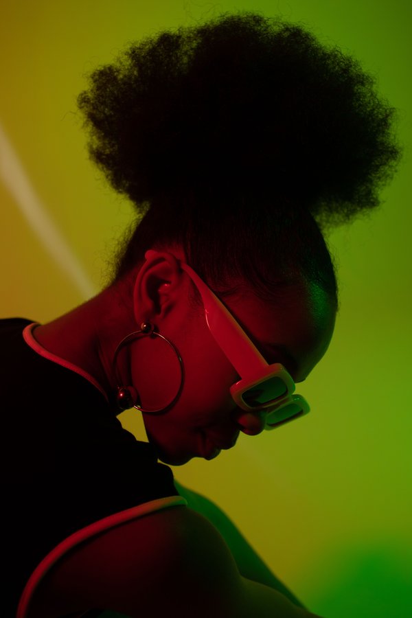 A listener in tinted glasses under green and red light